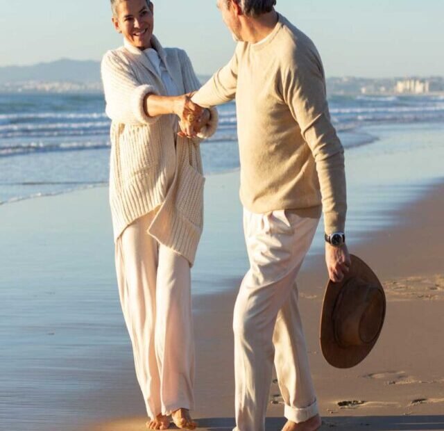 Um casal homem e mulher felizes na praia tranquilos por ter a proteção de seguro de vida resgatável.