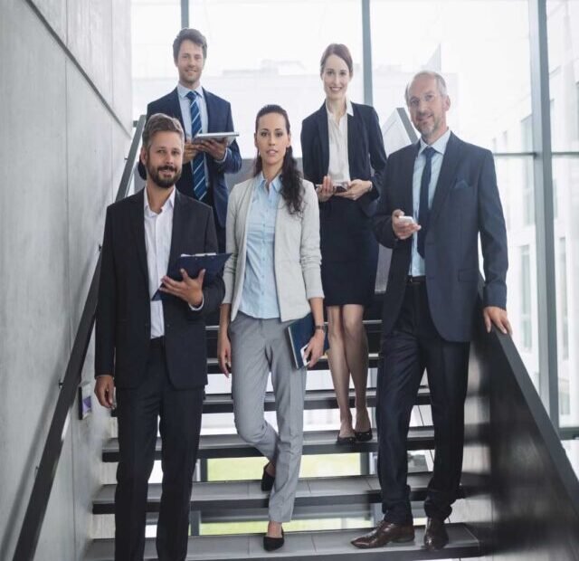 Cinco empresarios na escada.