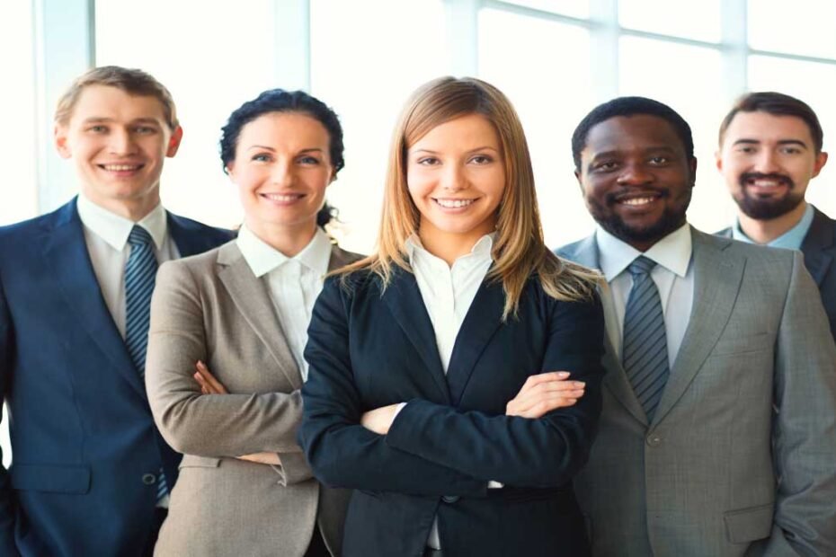 Execitivos homens e mulheres de braços cruzados sorrindo